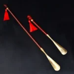 Deux chausse-pieds élégants : un long et un court, tous deux avec des manches en bois de santal et un chausse-pied en laiton.