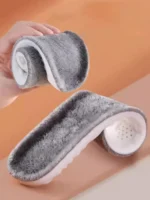 S78e26625842e4026871c2ae348092a6eq.webp Gros plan sur des chaussons gris doux et pelucheux à semelles blanches. Des chaussons confortables.