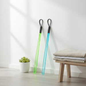 Chausse-pied long coloré (vert et bleu) de 59 cm appuyés contre un mur blanc.