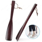 Chausse-pied en bois marron avec lanière en cuir, facilitant l'enfilage des chaussures.